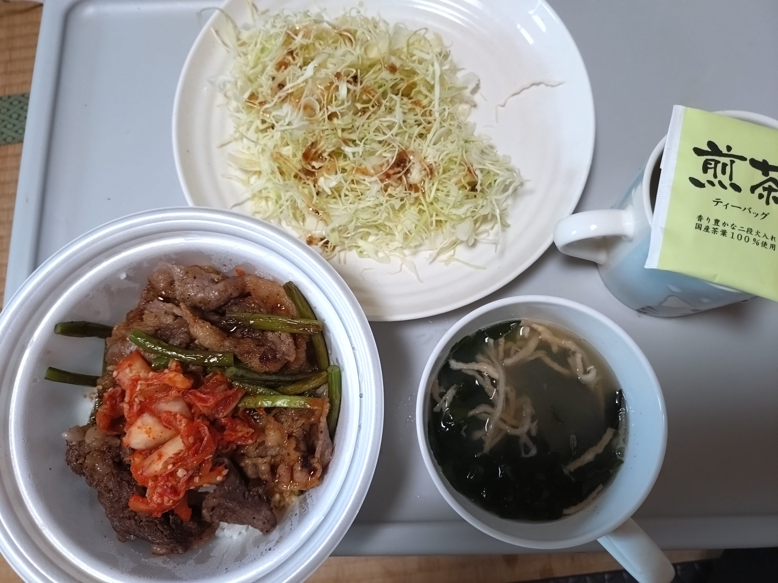 松屋 カルビと特選ブリスケット肉の合い盛り丼（フタなし・真上）味噌汁とキャベツとお茶を添えた食卓