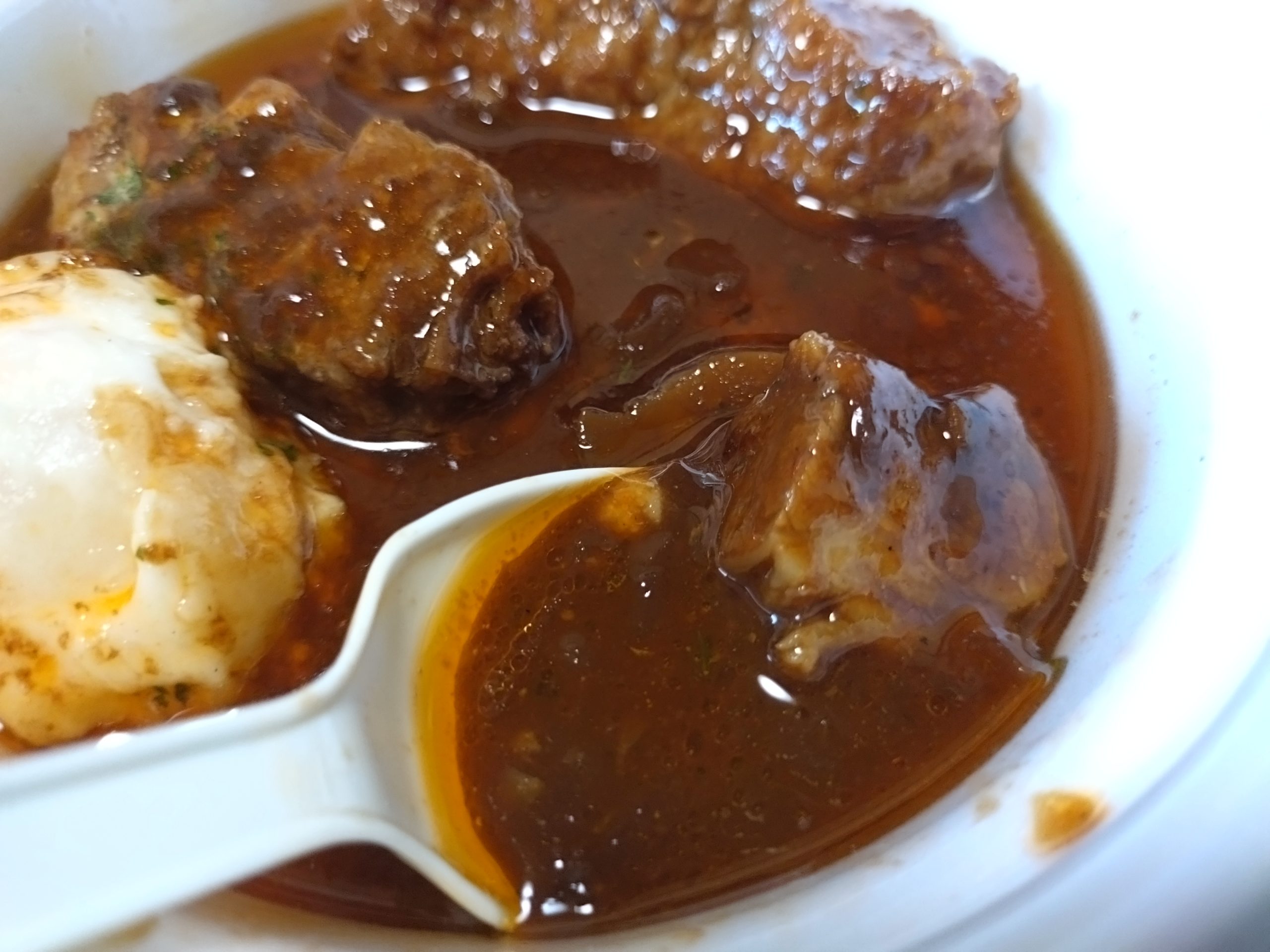 煮込みビーフシチューハンバーグ:濃厚ソースの質感 煮込みビーフシチューハンバーグのシチューソースをスプーンですくったところ
