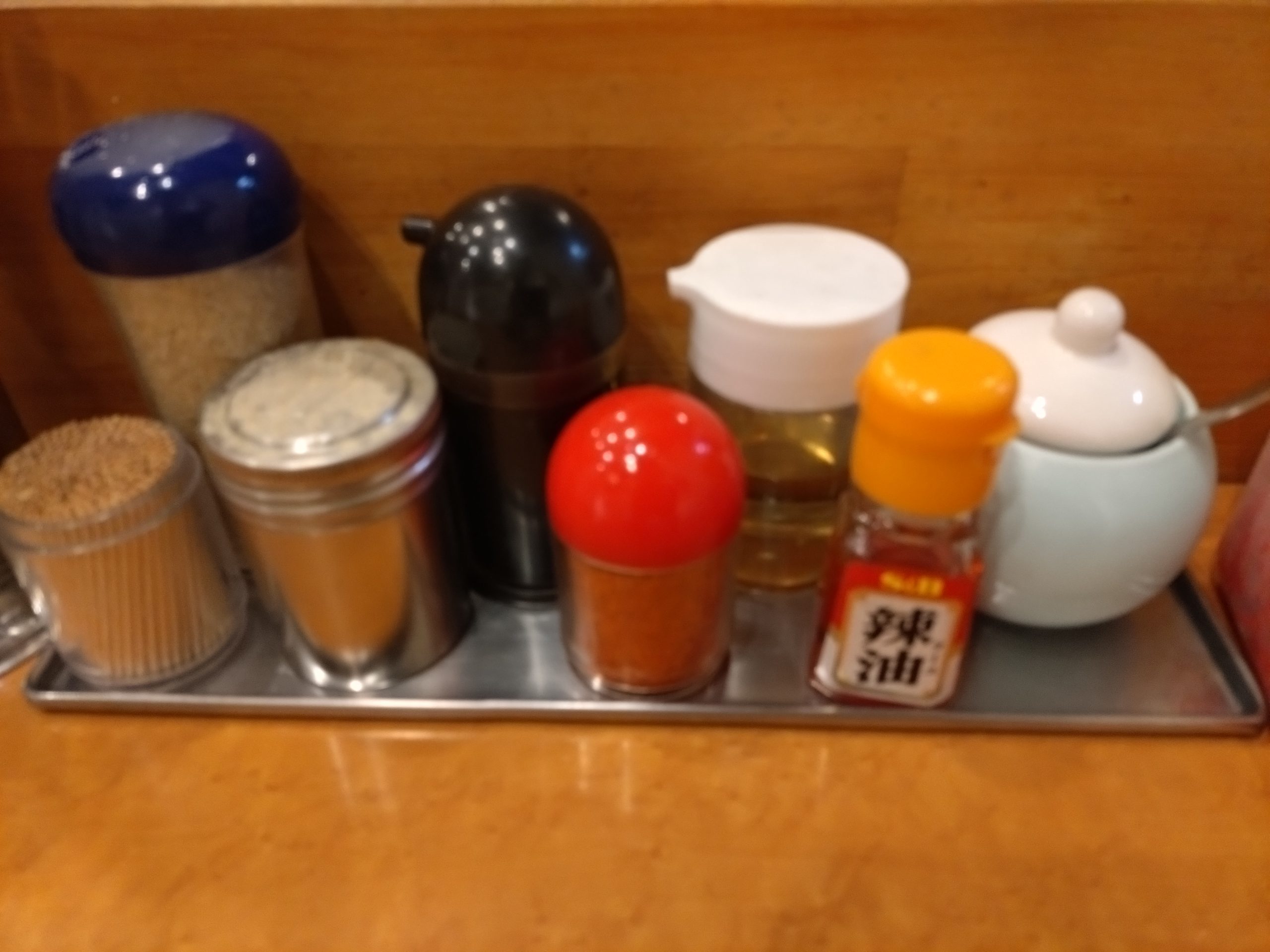 カウンターに並ぶ紅しょうがやにんにくなどの調味料