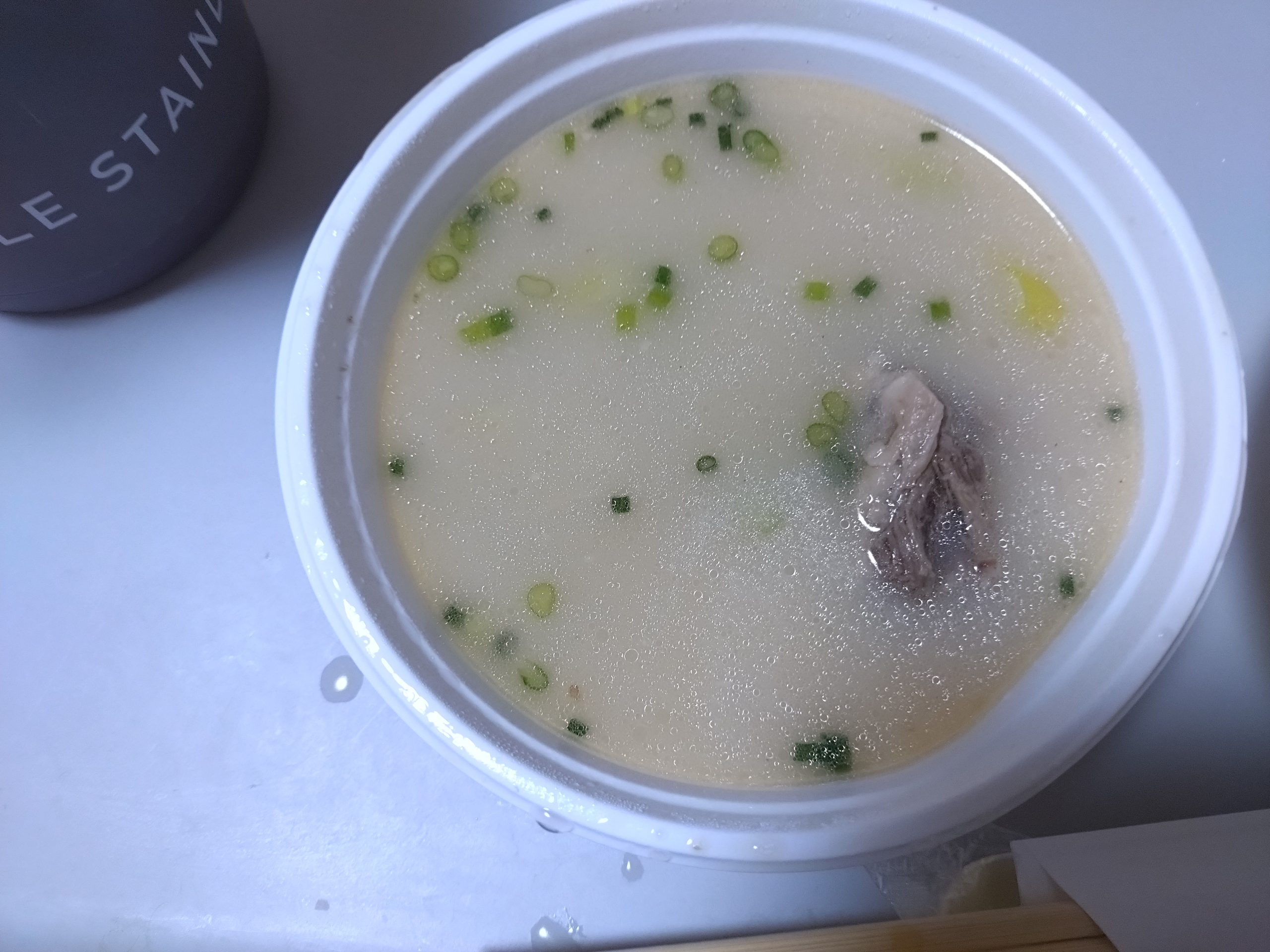 フタを外したコムタンスープ。白濁したスープにネギが見える