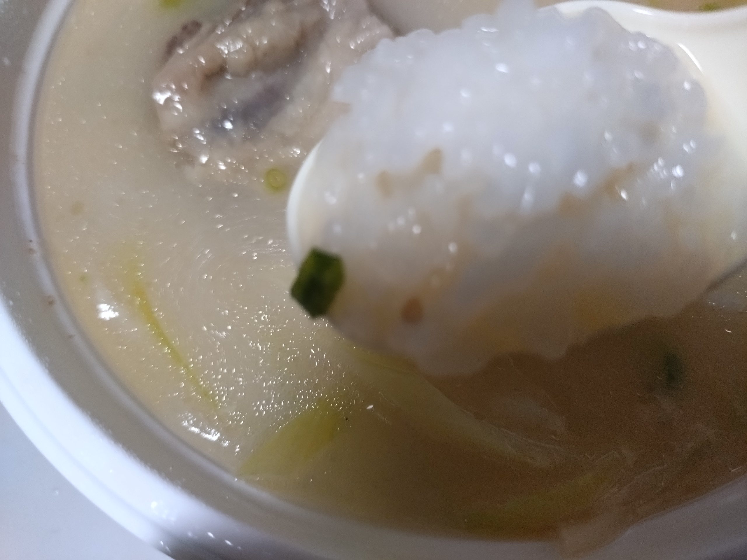 スプーンですくったコムタンクッパのご飯。スープを吸った白ご飯