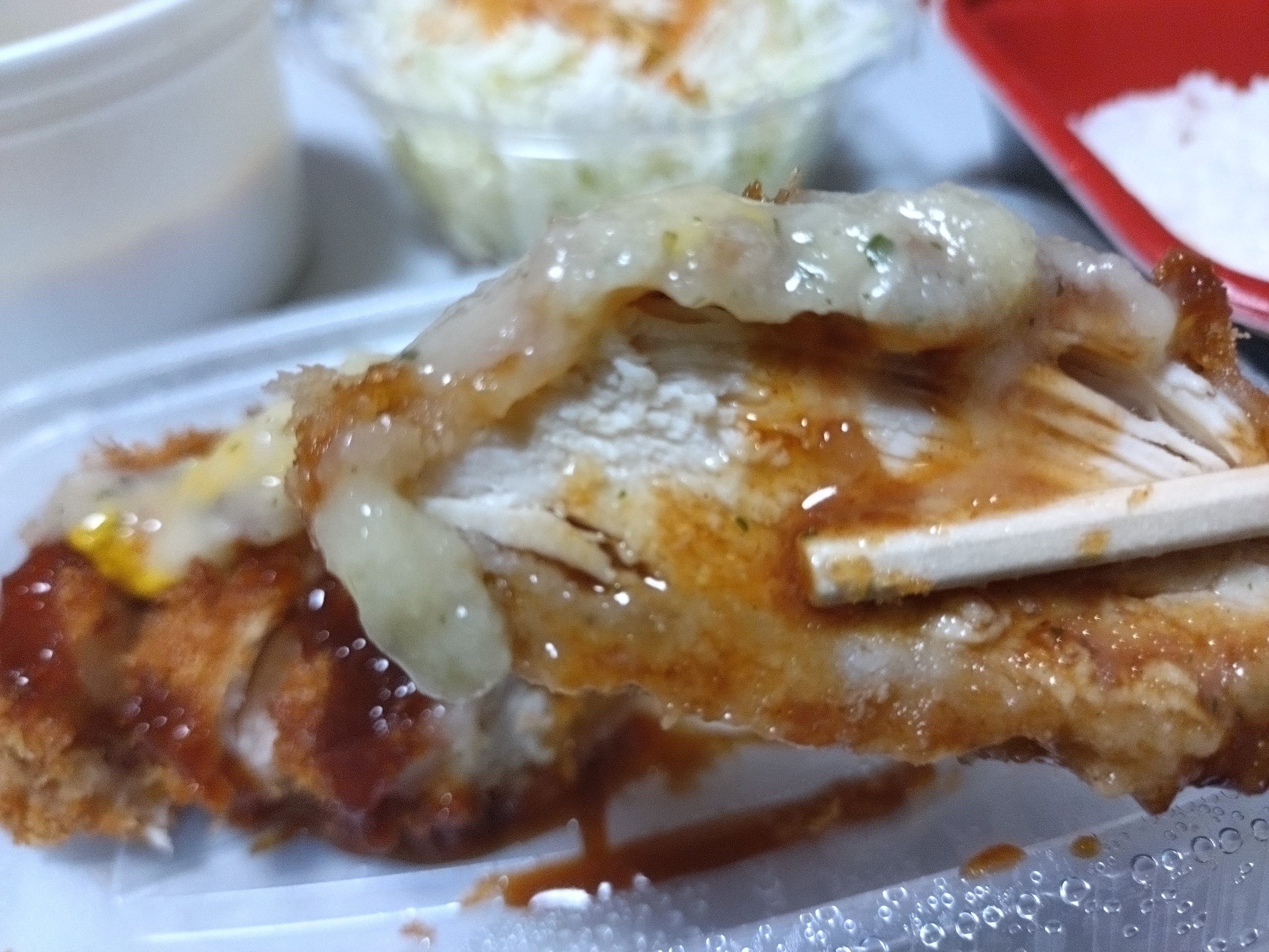 肉厚チキンムネかつにソースとからしとガーリックバターソースをかけたアップ写真