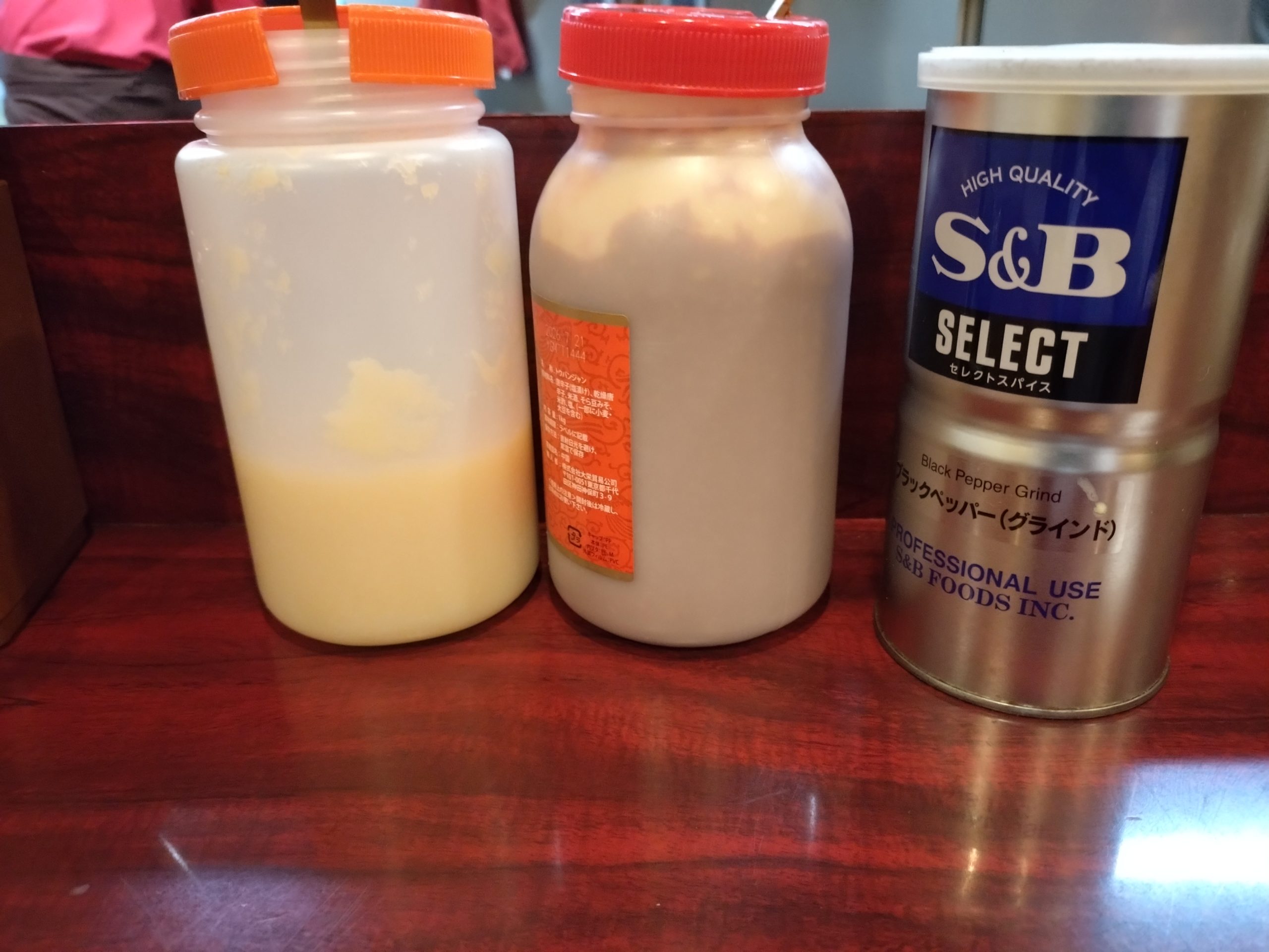 卓上調味料(にんにく・豆板醤など) 卓上のにんにくや豆板醤などの調味料。味変用のアイテムが並ぶ