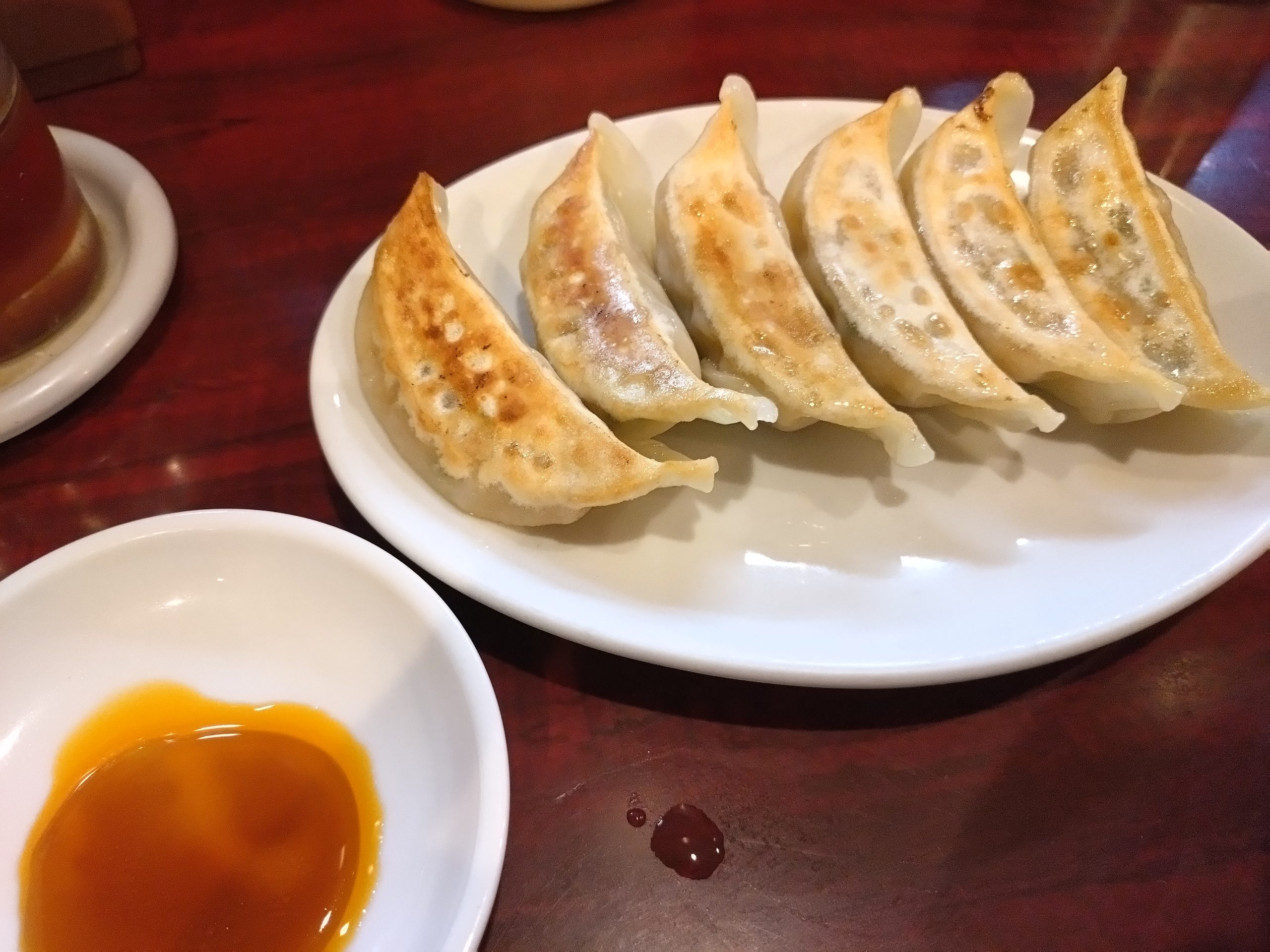 餃子(サイドメニュー) 焼き餃子。こんがり焼けた餃子が皿に並ぶ