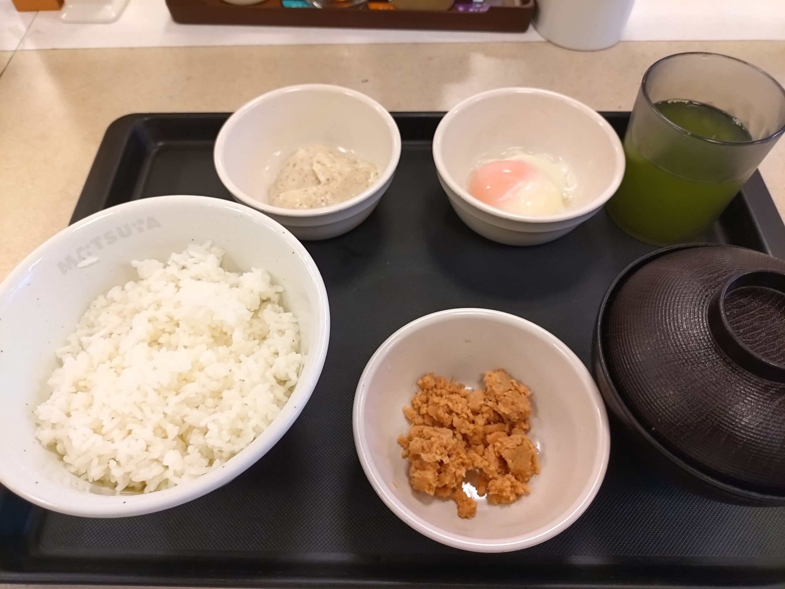 松屋 北海道産鮭の粗ほぐし玉子かけごはん 全景 松屋の朝定食 北海道産鮭の粗ほぐし玉子かけごはんの全景。ごはん、鮭、半熟玉子、とろろ、みそ汁が並ぶ