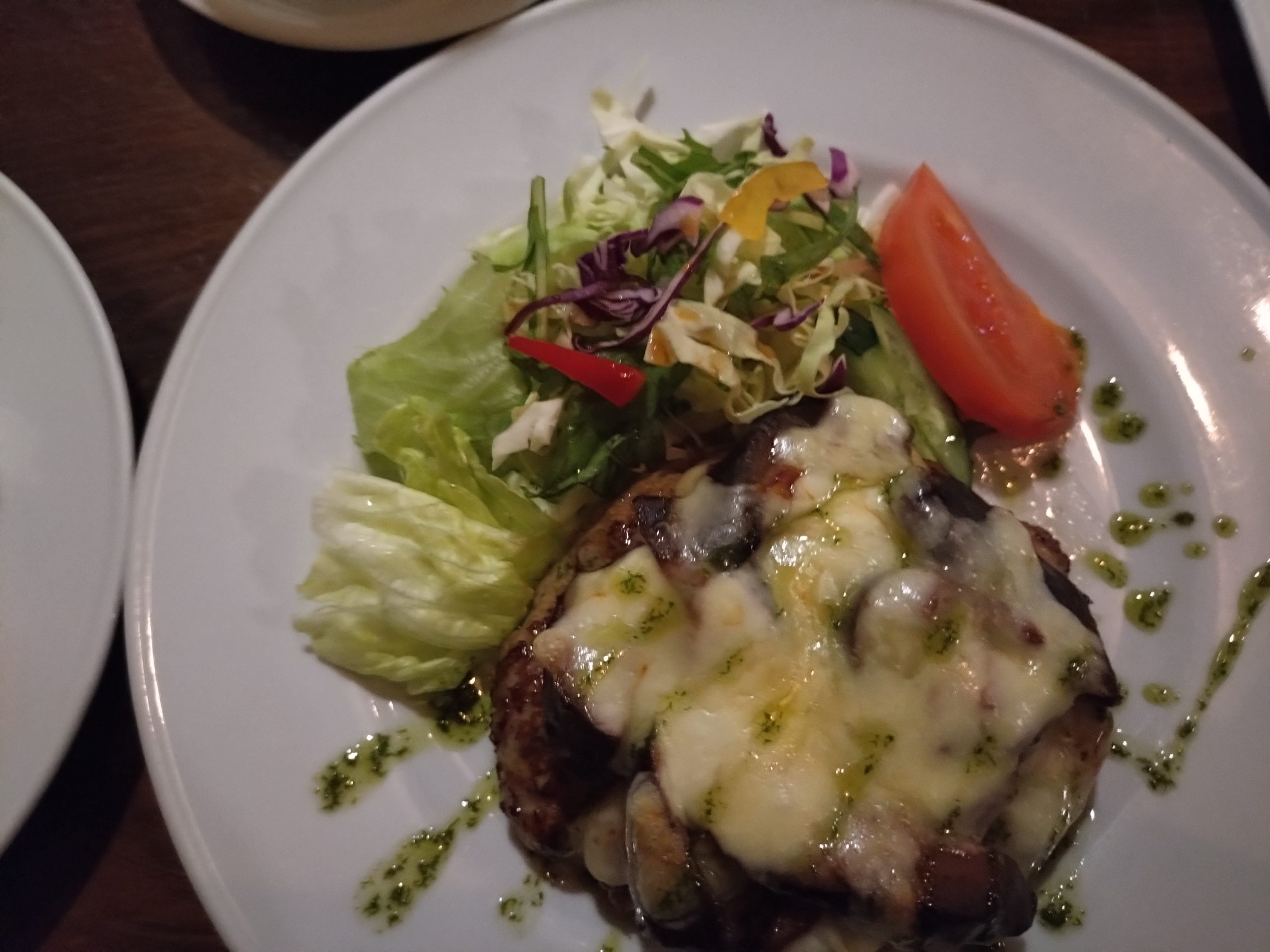 なすのチーズ焼きハンバーグ|上から なすのチーズ焼きハンバーグを上から撮影。チーズの広がりと緑のオイルが見える。