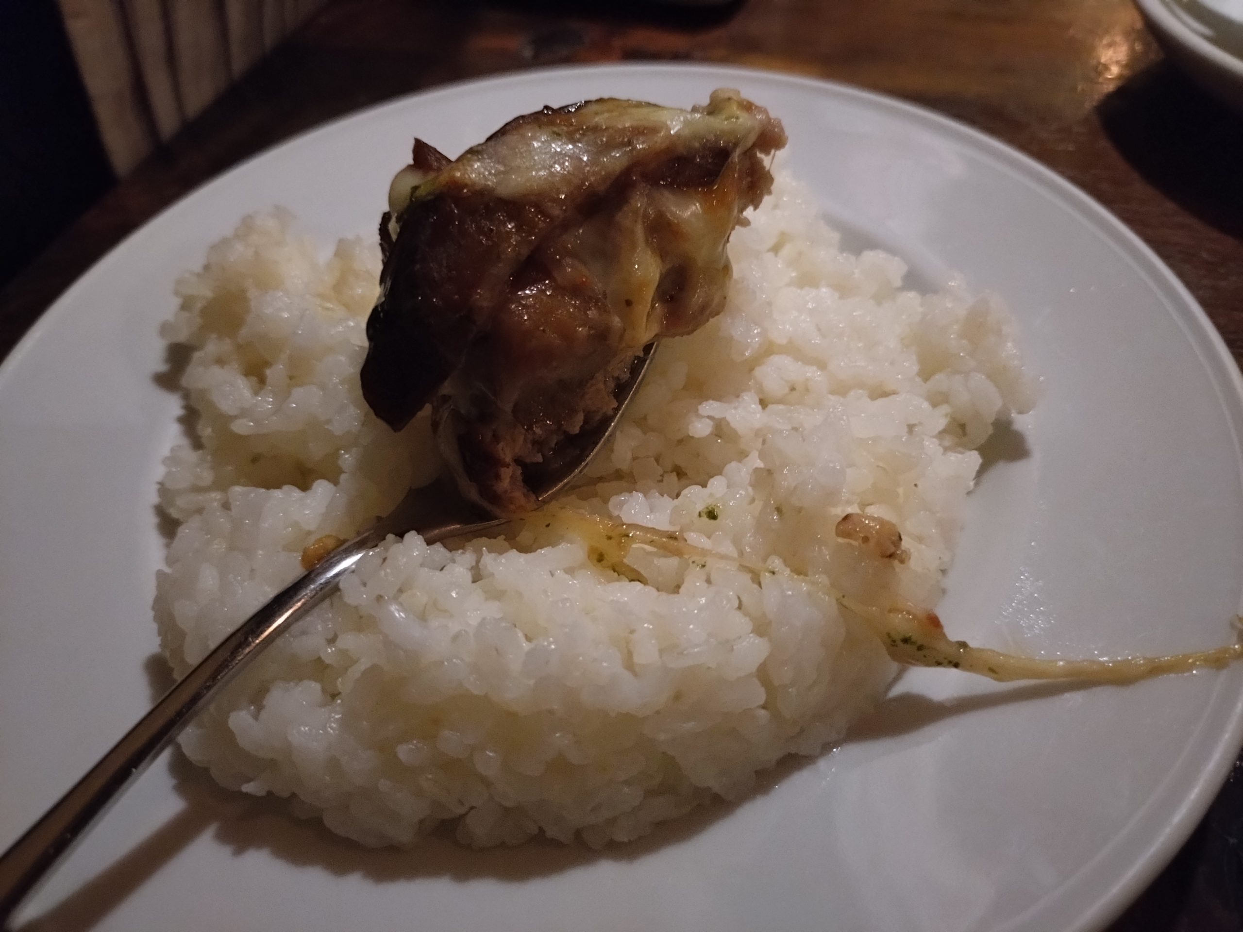 なすのチーズ焼きハンバーグ|ご飯の上 なすのチーズ焼きハンバーグをご飯の上に乗せた一口。