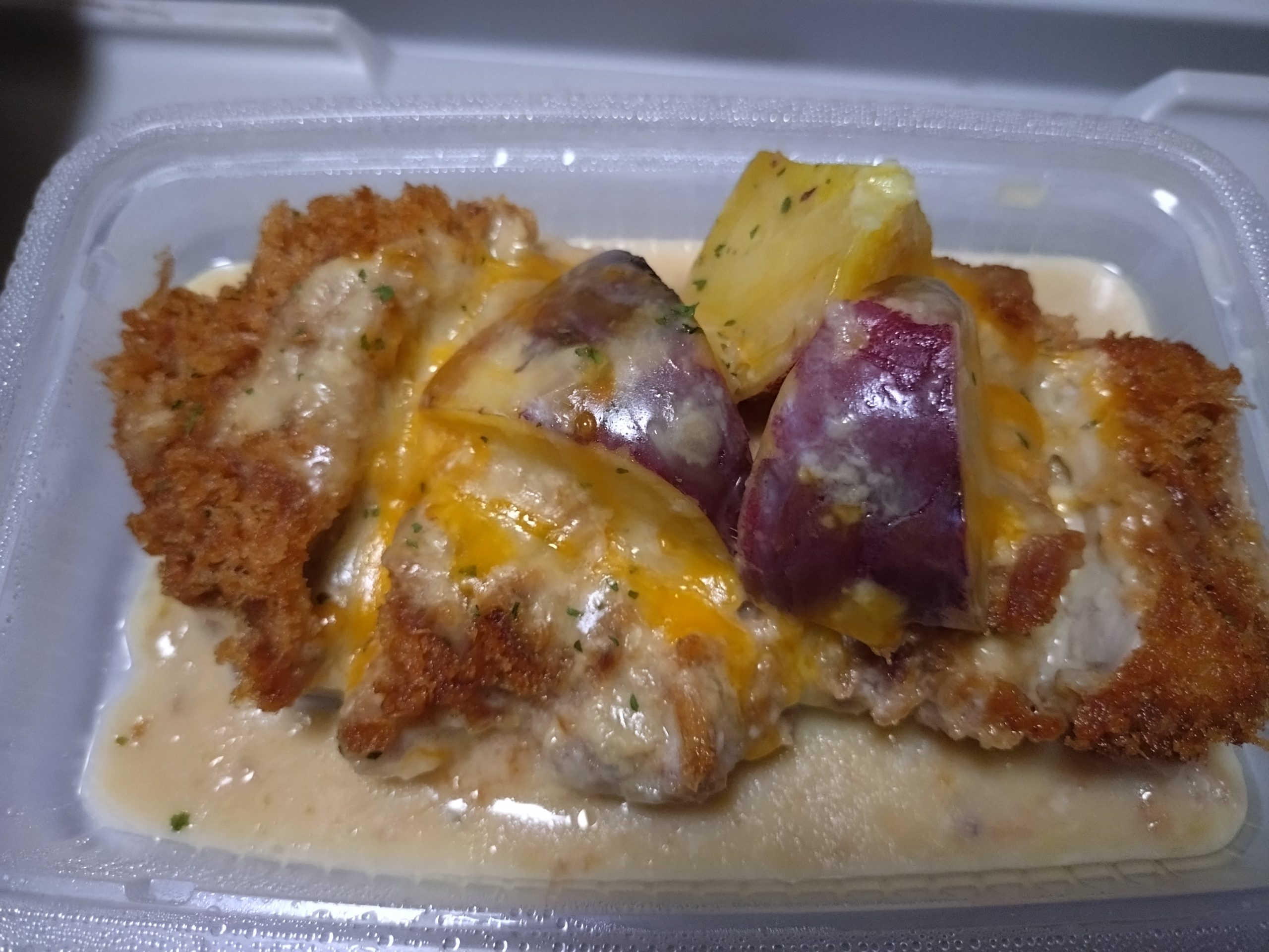 食べ進めた途中のシュクメルリチキンかつ定食。ソースが底に溜まり、具材の配置が変わっている様子