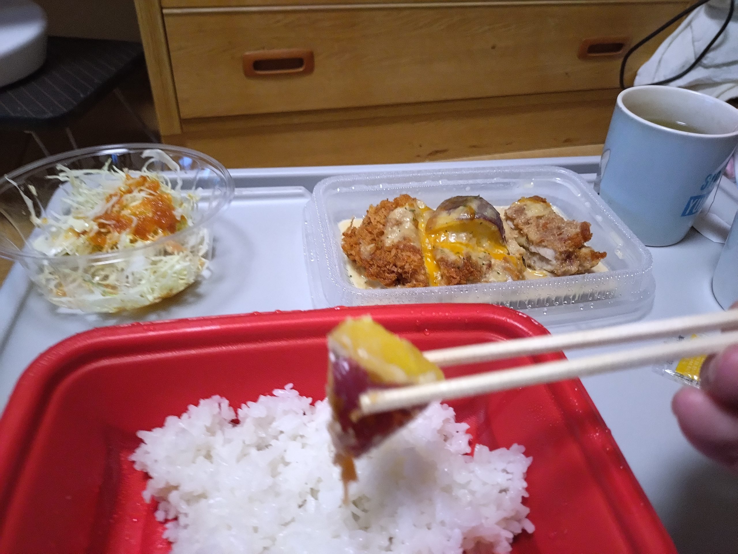 シュクメルリチキンかつ定食のチキンかつ断面。衣と肉の層が分かり、テイクアウト後の状態が確認できる