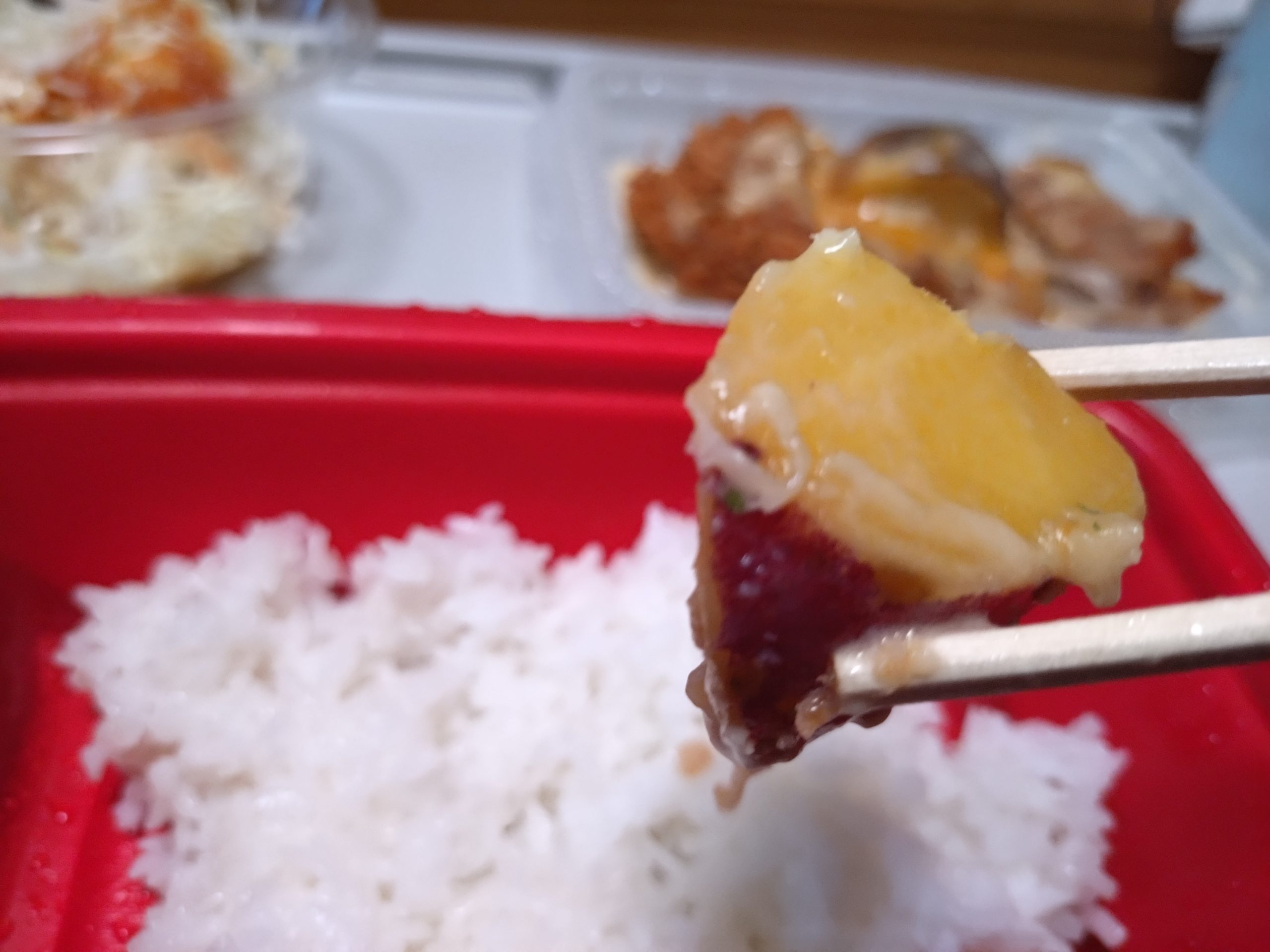 箸で持ち上げたサツマイモ。大きさと厚みが分かり、食感の主張が想像できる