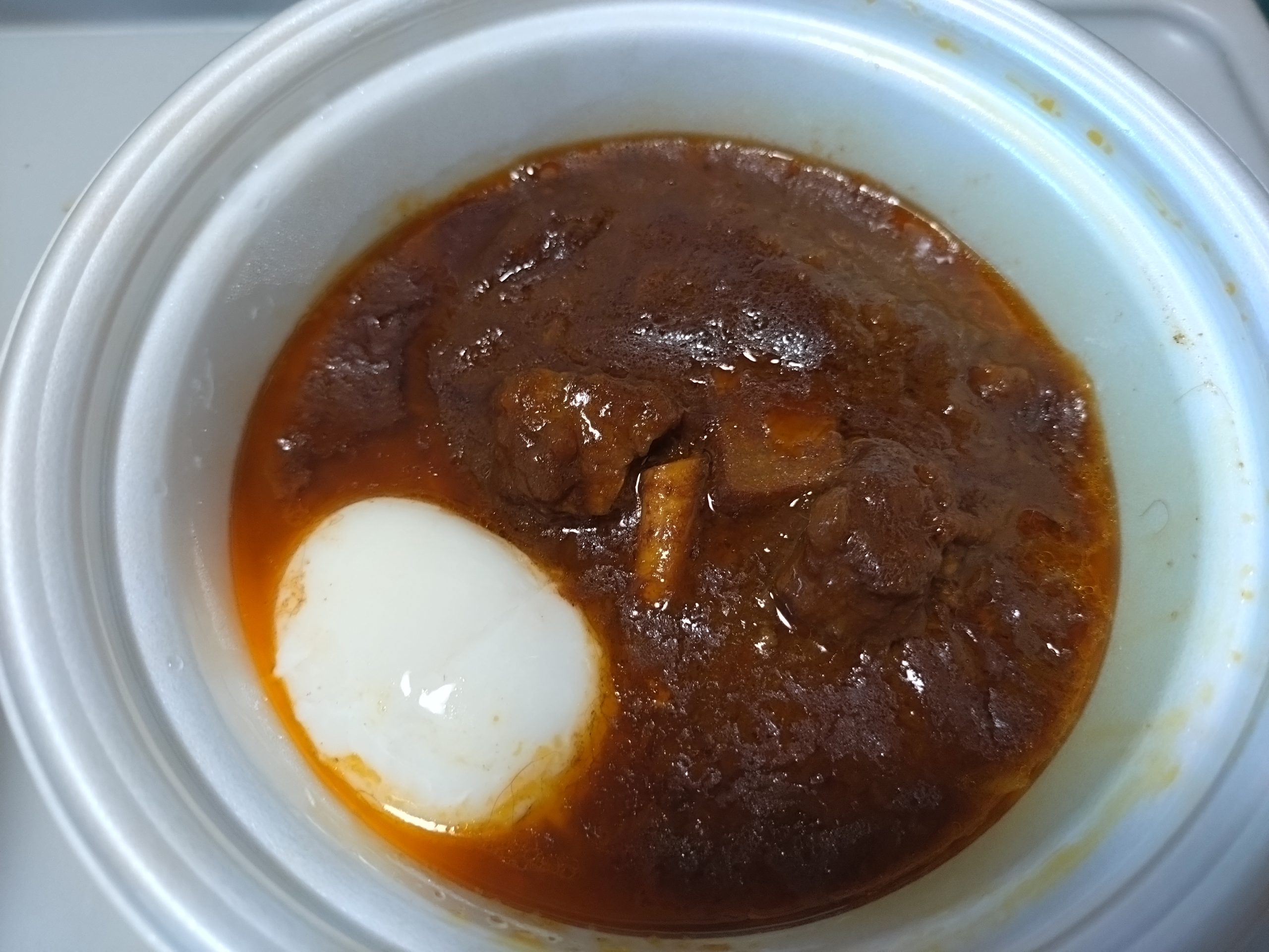 ハンバーグとカレーと温玉が同じ容器に入った状態