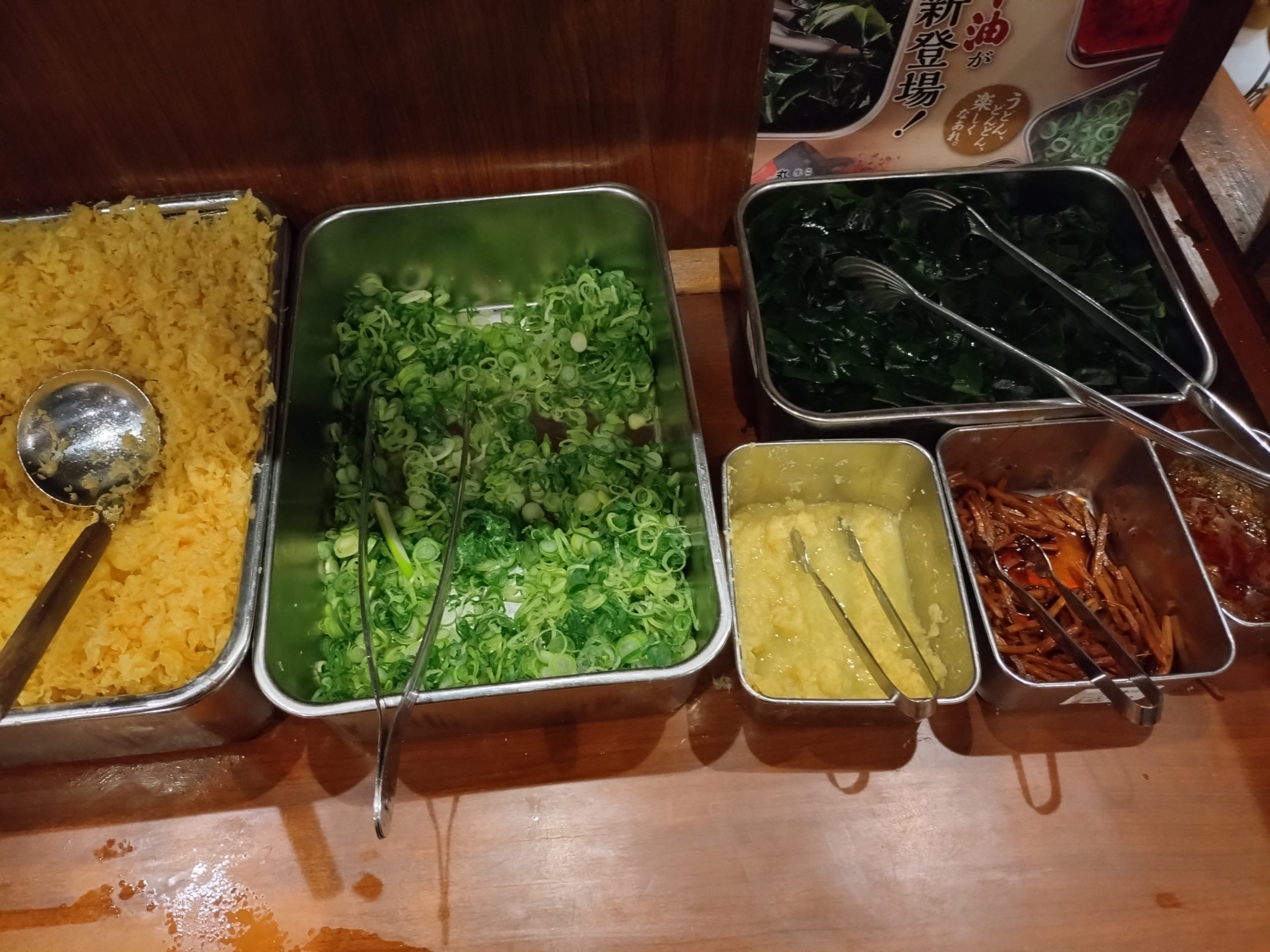 丸亀製麺の無料トッピング（ねぎ・わかめ）コーナーの様子