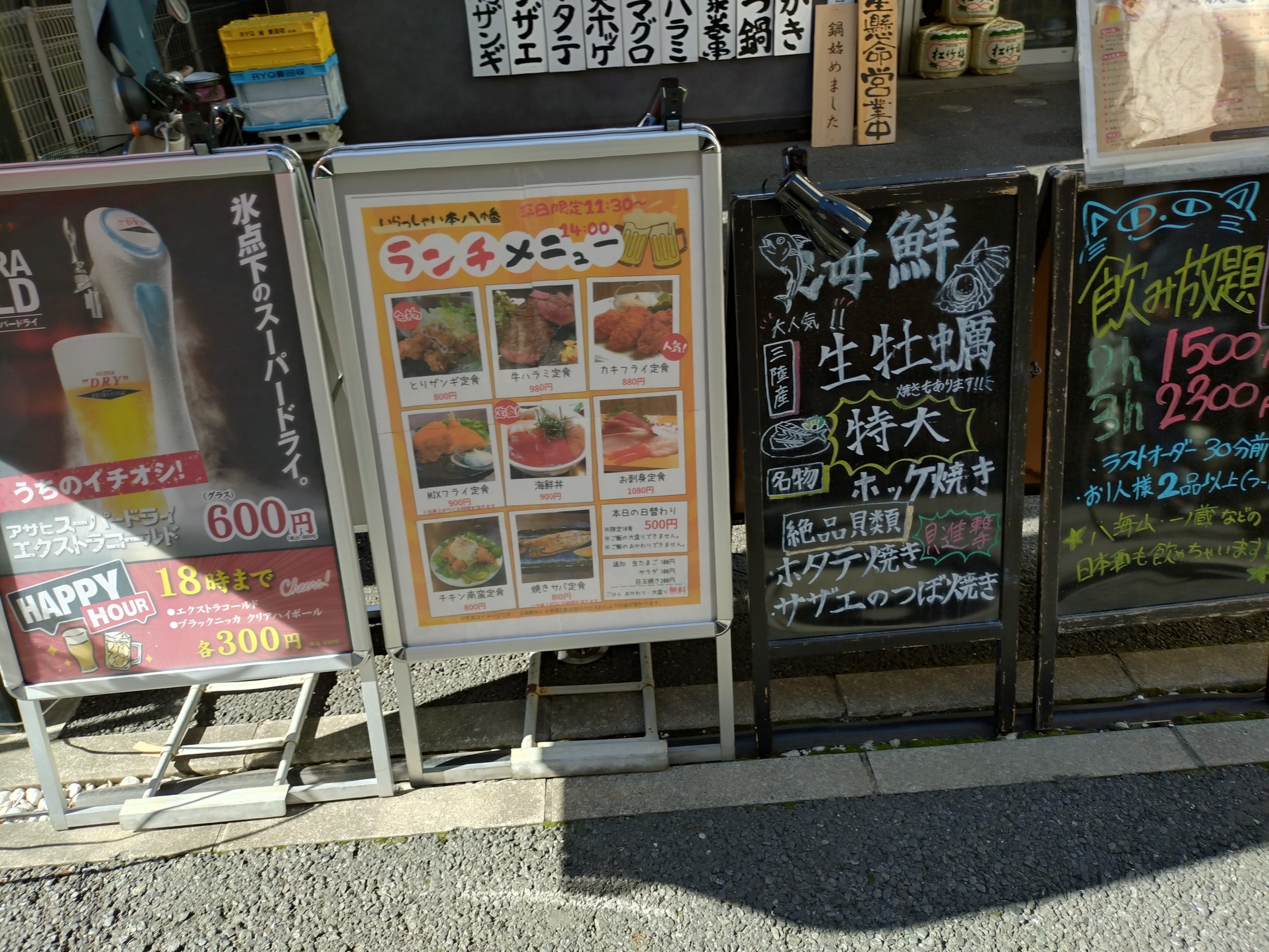 旬鮮酒場いらっしゃい！の外観前にある看板（ランチ営業の案内）