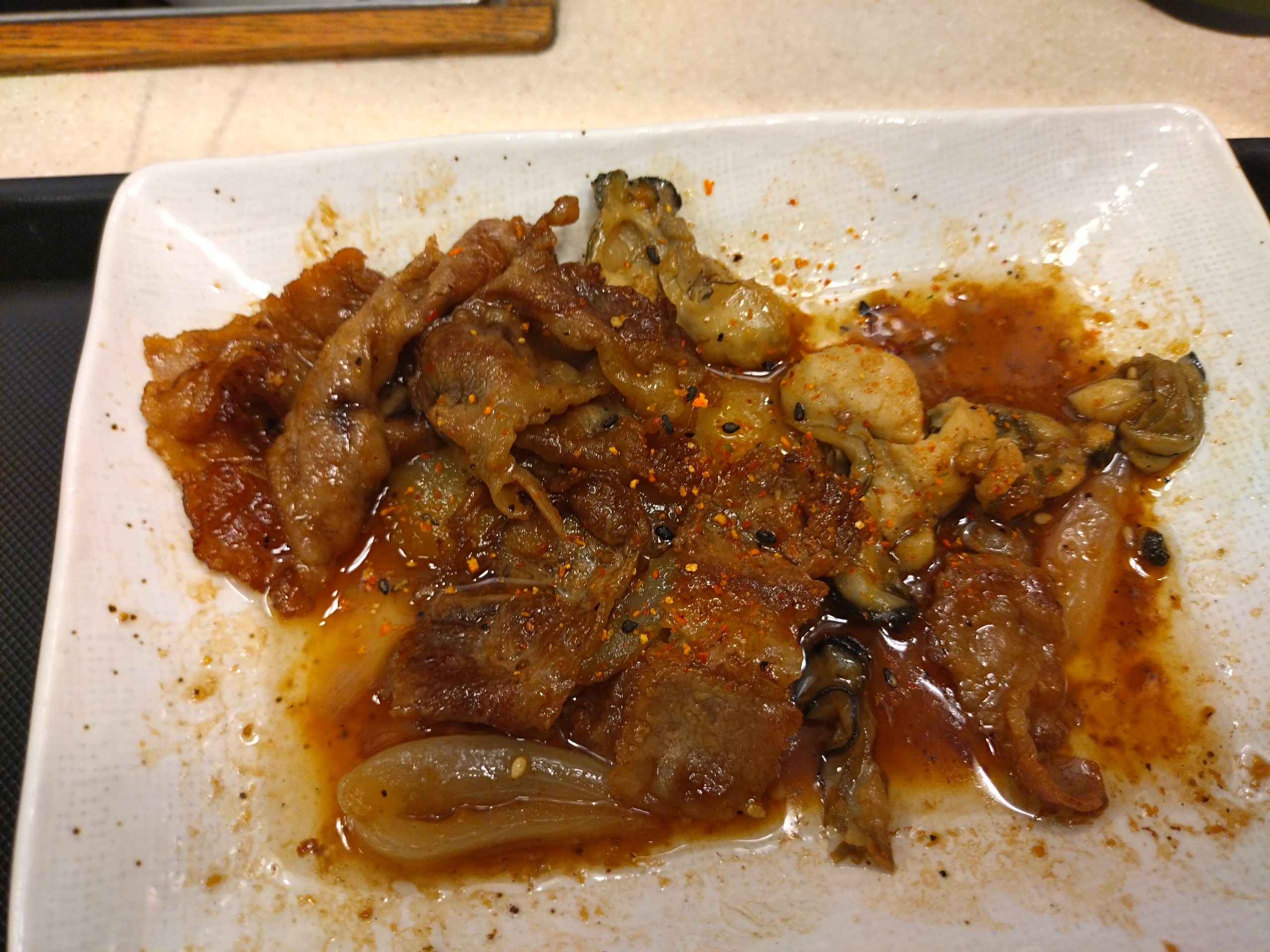 七味はソースに埋もれる 松屋 牛肉と牡蠣のオイスターソース炒め定食 七味をかけた写真