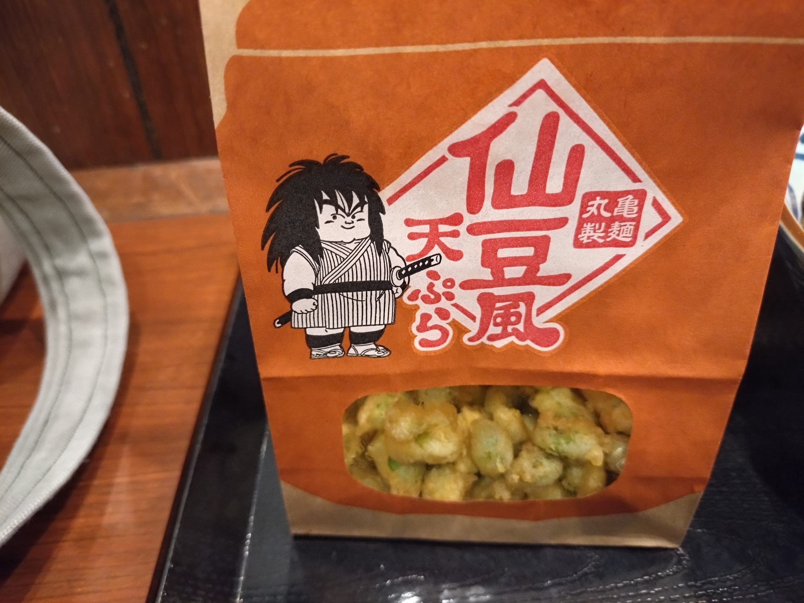 丸亀製麺ドラゴンボールコラボ仙豆風天ぷらの袋。ヤジロベーのイラスト