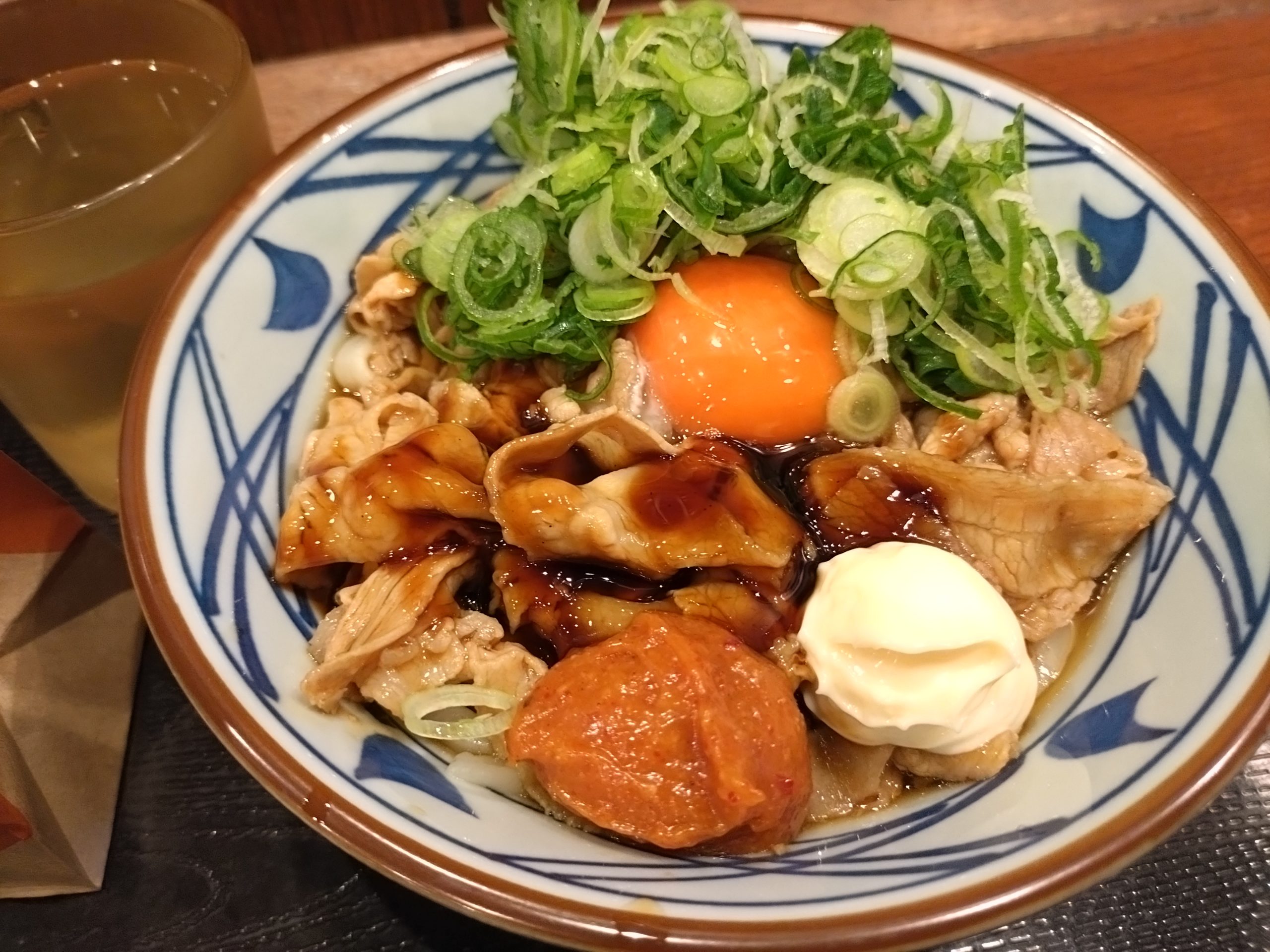 丸亀製麺こく旨豚玉ぶっかけうどん並。豚肉と卵黄とネギがのったぶっかけうどん